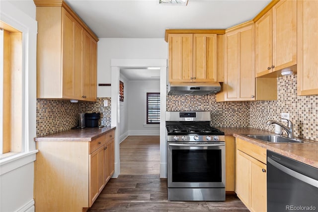 kitchen featuring light brown cabinetry, under cabinet range hood, a sink, dark wood finished floors, and appliances with stainless steel finishes