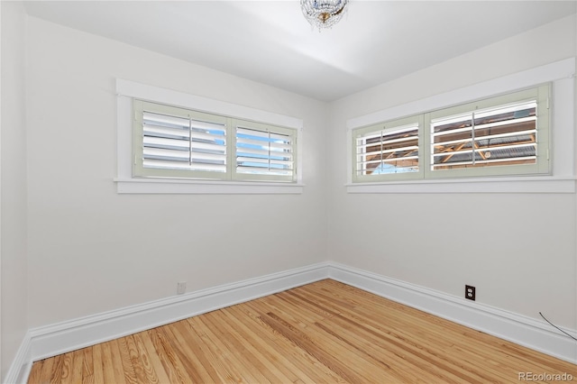 spare room with light wood-style floors and baseboards