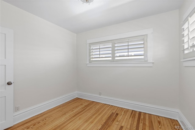 unfurnished room with baseboards and light wood-style flooring