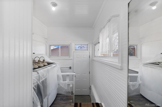 clothes washing area with wood finished floors and crown molding