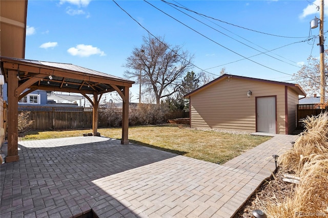 view of patio / terrace featuring a gazebo, a fenced backyard, and an outdoor structure