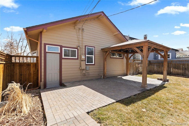 back of property featuring a gazebo, a patio area, a lawn, and a fenced backyard