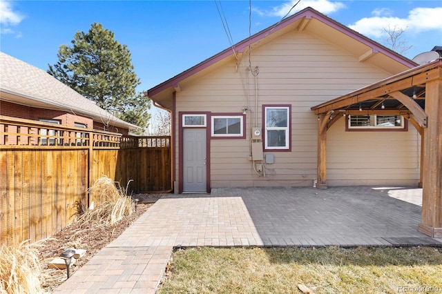 rear view of house featuring a patio and fence