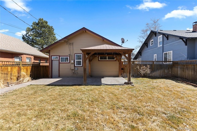 back of house with a gazebo, a lawn, a fenced backyard, and a patio area