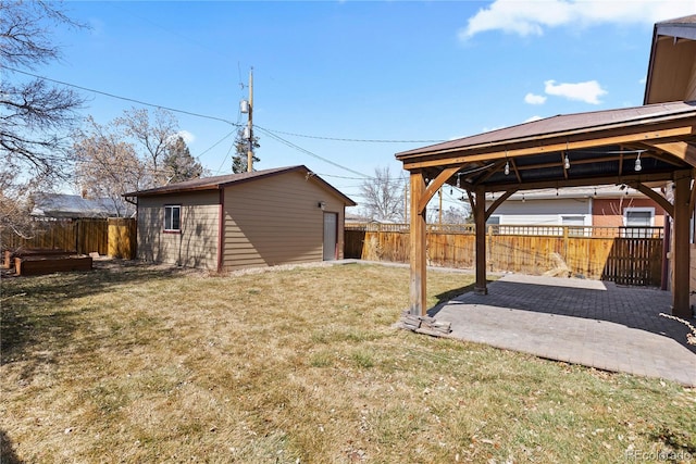 view of yard with a gazebo, a patio, an outbuilding, and a fenced backyard