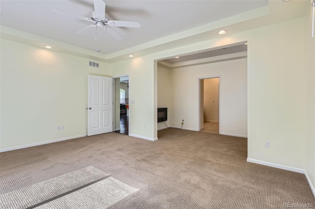 5495 Espana Ct, Denver, CO 80249 - empty room with light colored carpet, a tray ceiling, recessed lighting, and a ceiling fan
