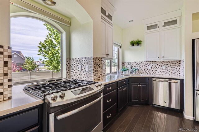 5495 Espana Ct, Denver, CO 80249 - kitchen with stainless steel appliances, white cabinets, light countertops, and decorative backsplash