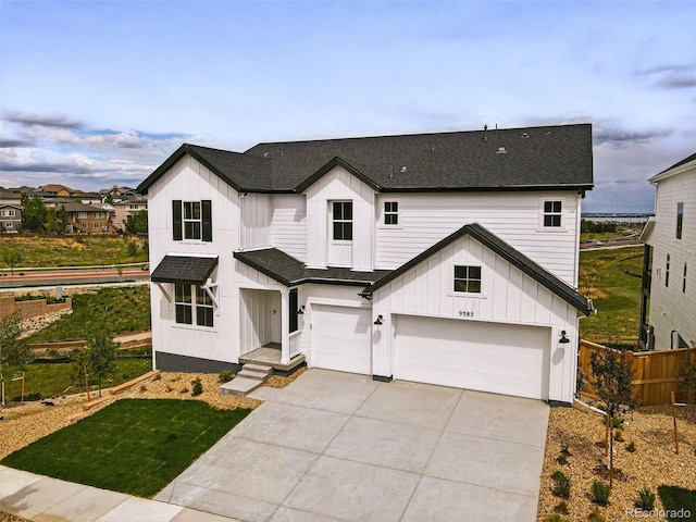 9382 Quaker St, Arvada, CO 80007 - modern farmhouse style home featuring a shingled roof, board and batten siding, an attached garage, and concrete driveway