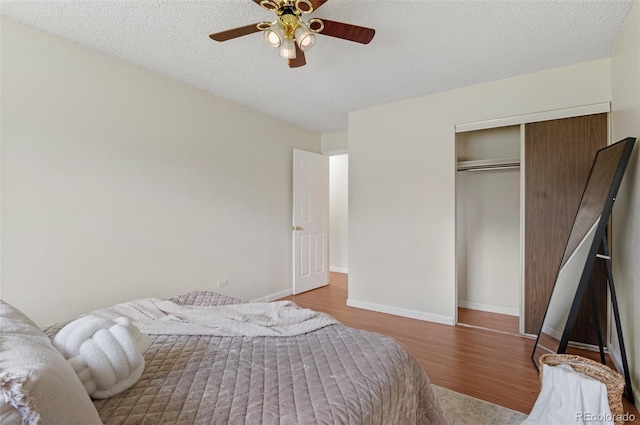 9650 Huron St Unit 12, Thornton, CO 80260 - bedroom with wood finished floors, a closet, a textured ceiling, baseboards, and ceiling fan
