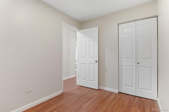 9650 Huron St Unit 12, Thornton, CO 80260 - unfurnished bedroom featuring light wood-type flooring, baseboards, and a closet