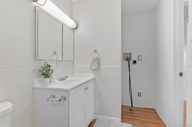 9650 Huron St Unit 12, Thornton, CO 80260 - half bath featuring vanity, wood finished floors, tile walls, and toilet
