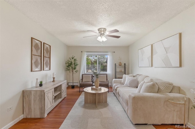 9650 Huron St Unit 12, Thornton, CO 80260 - living area with a baseboard radiator, ceiling fan, light wood-type flooring, and a textured ceiling