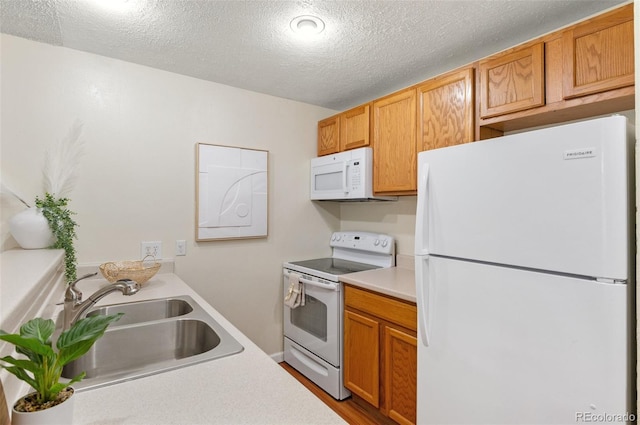 9650 Huron St Unit 12, Thornton, CO 80260 - kitchen with white appliances, light countertops, a textured ceiling, and wood finished floors