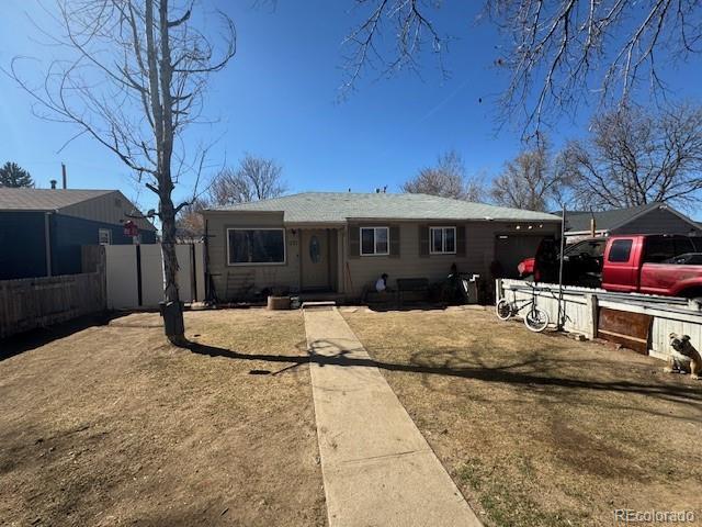 view of front facade with a front yard, fence, and driveway