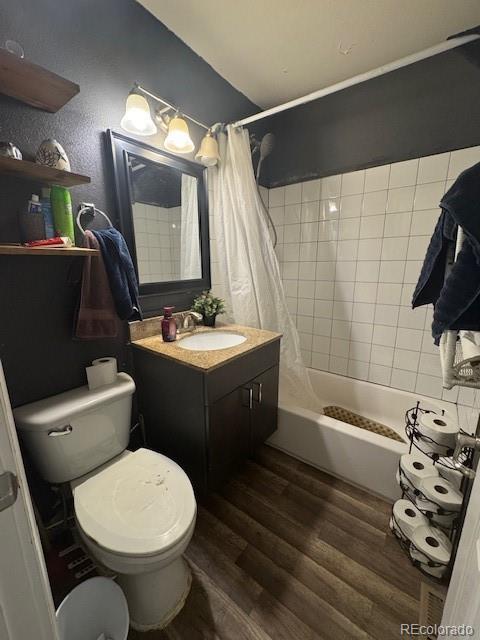 full bath with shower / bath combination with curtain, toilet, vanity, and wood finished floors