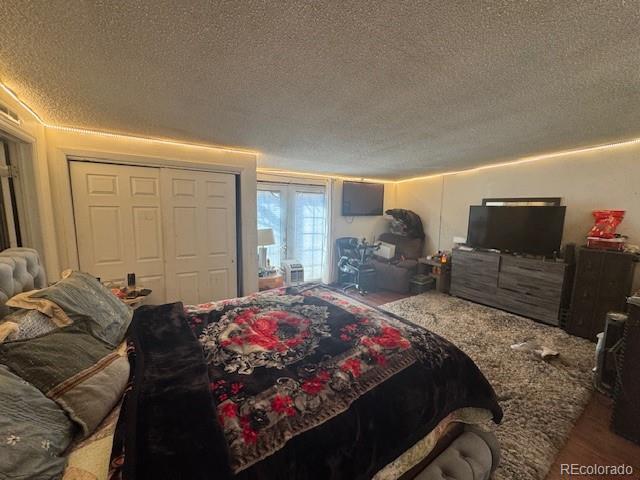 bedroom featuring a closet, a textured ceiling, and wood finished floors