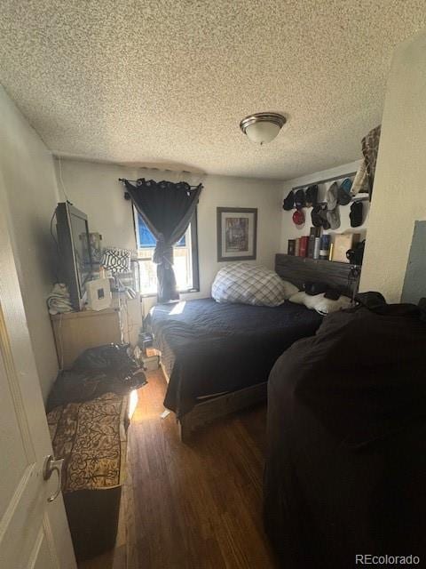 bedroom featuring a textured ceiling and wood finished floors