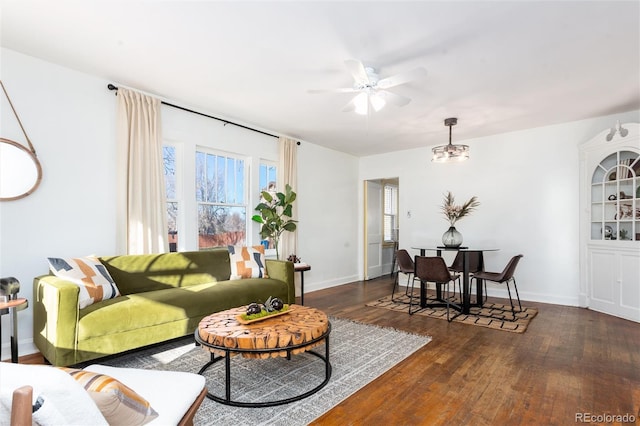 living room featuring ceiling fan and dark hardwood / wood-style flooring