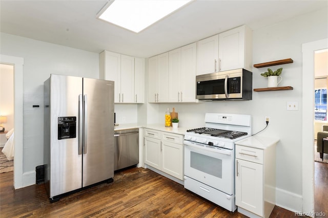 kitchen featuring stainless steel appliances, white cabinetry, and dark wood-type flooring