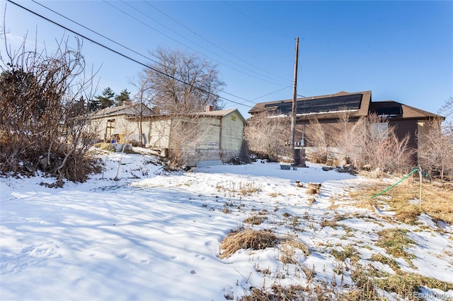 view of snow covered back of property