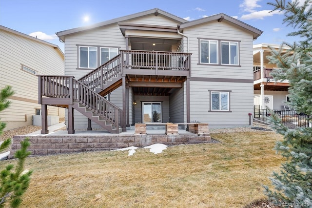 back of property with a wooden deck, a yard, and a patio