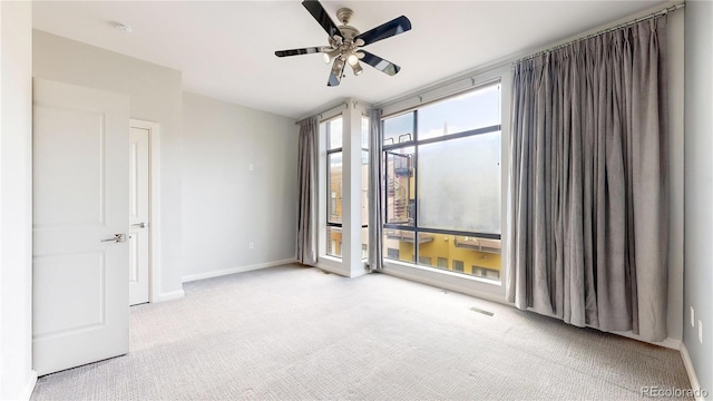 empty room featuring ceiling fan and light carpet