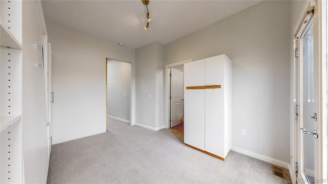 unfurnished bedroom featuring a closet and light colored carpet