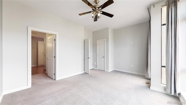 unfurnished bedroom with ceiling fan and light carpet