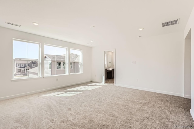 unfurnished living room with recessed lighting, carpet floors, visible vents, and baseboards