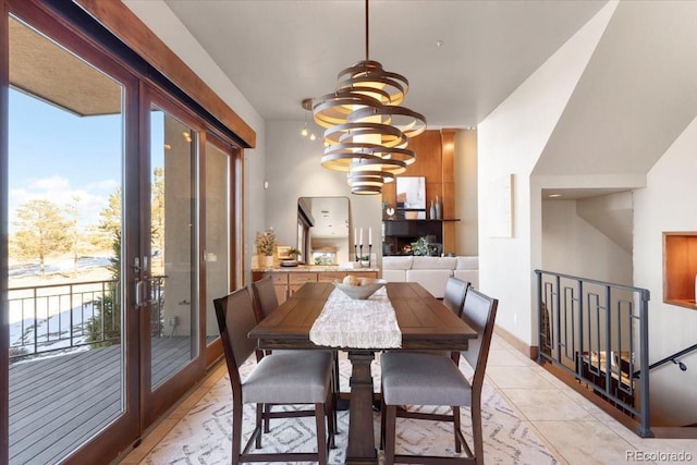 tiled dining space with a notable chandelier and french doors