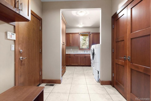 laundry area with cabinets, washer / dryer, sink, and light tile patterned floors