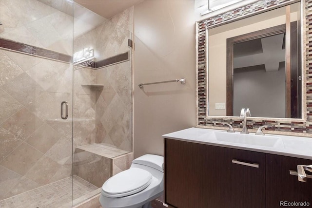 bathroom with vanity, an enclosed shower, backsplash, and toilet