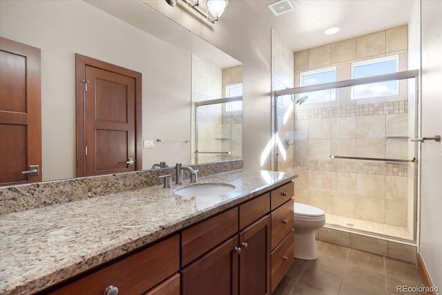 bathroom with an enclosed shower, vanity, tile patterned floors, and toilet