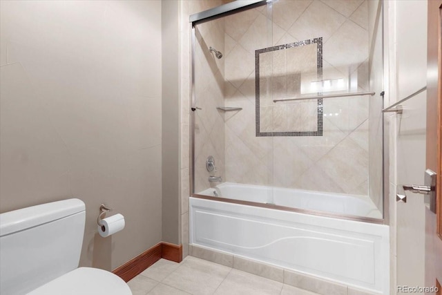 bathroom featuring enclosed tub / shower combo, toilet, and tile patterned flooring