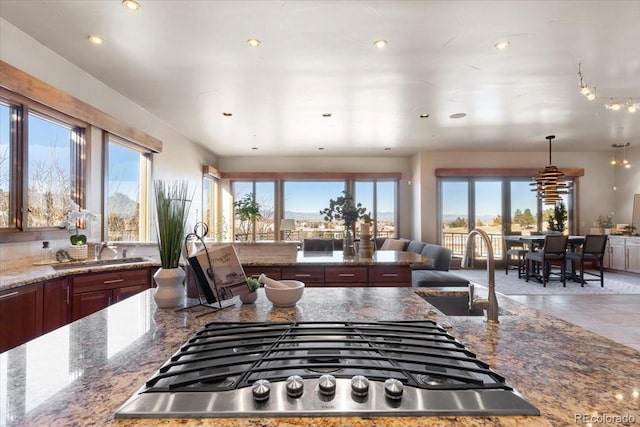 kitchen featuring a wealth of natural light, sink, stainless steel gas cooktop, and pendant lighting