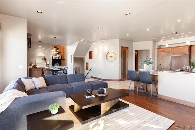 living area with baseboards, light wood-style flooring, and recessed lighting