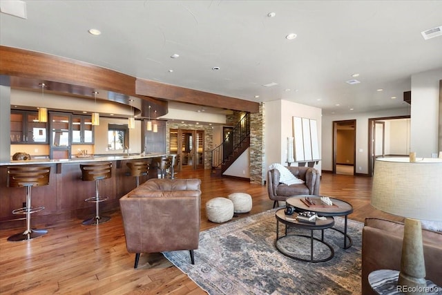 living room with a community bar, light wood-style floors, visible vents, and recessed lighting