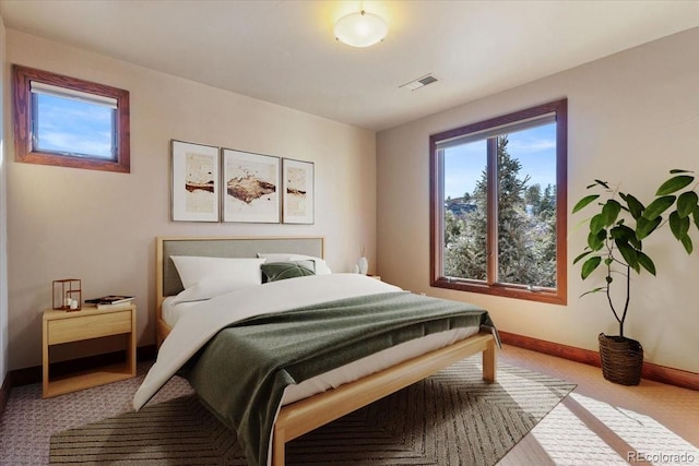 carpeted bedroom featuring visible vents and baseboards