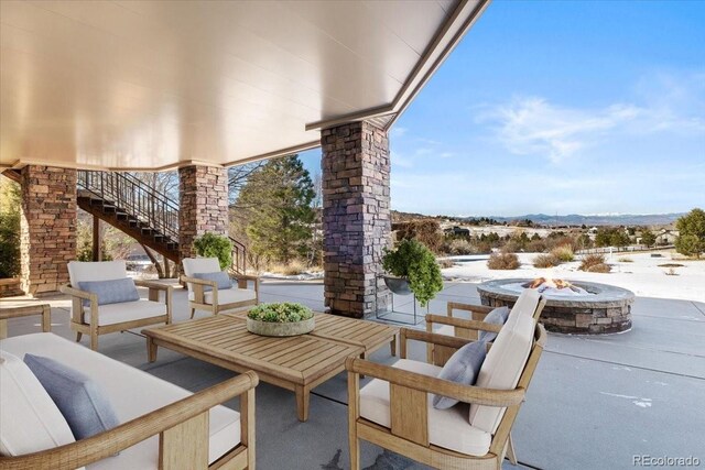 view of patio / terrace with stairway and an outdoor living space with a fire pit