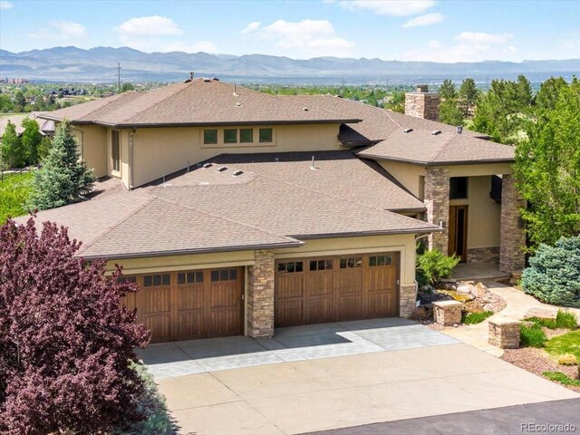 10370 Grande Vista Ct, Lone Tree, CO 80124 - prairie-style house featuring stone siding, a mountain view, stucco siding, and an attached garage