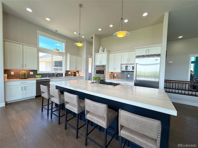 3125 Red Kit Rd, Franktown, CO 80116 - kitchen featuring stainless steel appliances, a towering ceiling, white cabinetry, dark wood finished floors, and decorative backsplash