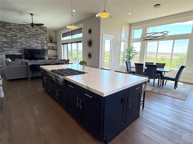 3125 Red Kit Rd, Franktown, CO 80116 - kitchen with stainless steel gas cooktop, dark cabinets, ceiling fan, healthy amount of natural light, and recessed lighting