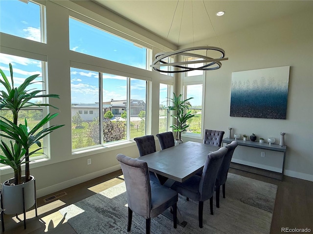 3125 Red Kit Rd, Franktown, CO 80116 - dining area featuring healthy amount of natural light, wood finished floors, a chandelier, a high ceiling, and recessed lighting