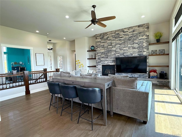 3125 Red Kit Rd, Franktown, CO 80116 - living room featuring dark wood finished floors, ceiling fan, a stone fireplace, built in shelves, and recessed lighting