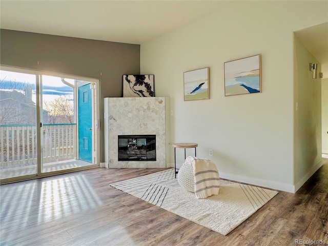 sitting room with hardwood / wood-style flooring and a tiled fireplace