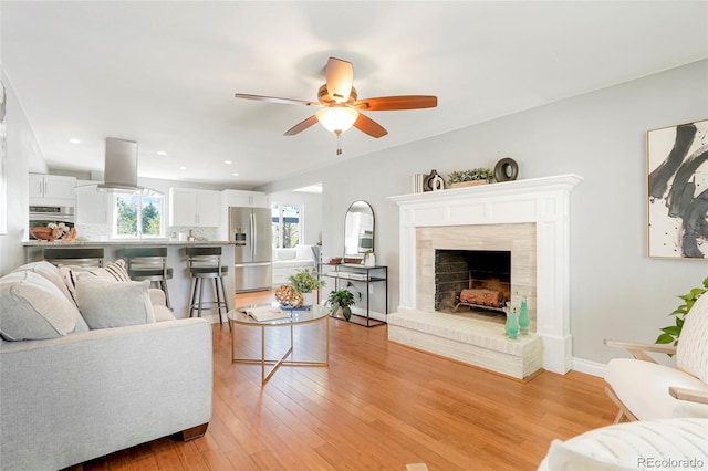 978 Mercury Cir, Lone Tree, CO 80124 - living room with ceiling fan, a tile fireplace, and light wood finished floors