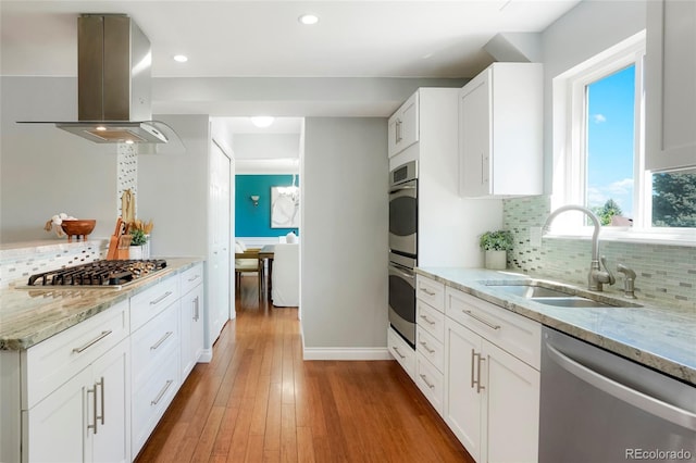 978 Mercury Cir, Lone Tree, CO 80124 - kitchen with stainless steel appliances, island exhaust hood, decorative backsplash, white cabinetry, and recessed lighting