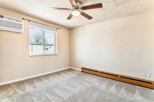 empty room with a baseboard radiator, an AC wall unit, carpet flooring, a textured ceiling, and baseboards