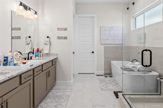 1881 Blossom Grove Dr, Windsor, CO 80550 - full bathroom with a stall shower, double vanity, a freestanding tub, tile patterned floors, and baseboards