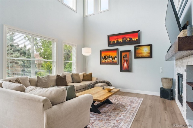 10029 Winterthur Ct, Highlands Ranch, CO 80129 - living room featuring a wealth of natural light, a fireplace, light wood-type flooring, and a towering ceiling